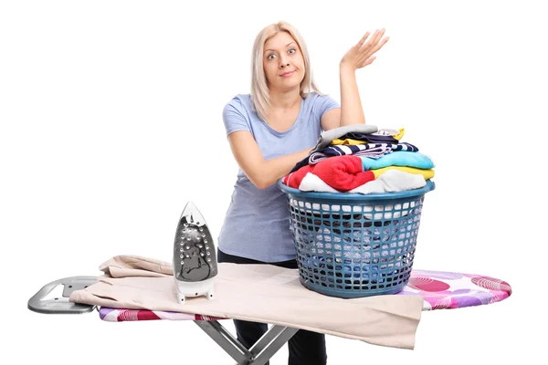 Woman standing behind an ironing board — Stock Photo, Image