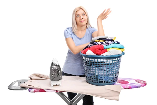 Mujer de pie detrás de una tabla de planchar —  Fotos de Stock