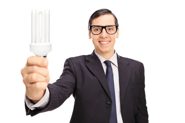 Young businessman holding  bulb — Stock Photo, Image