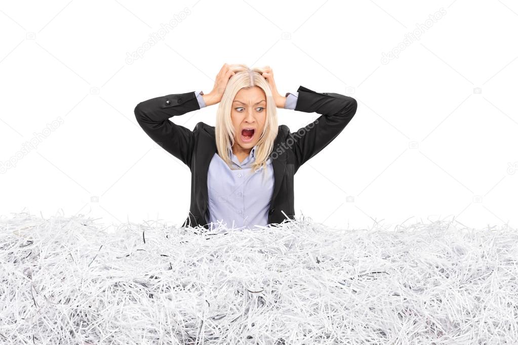 businesswoman stuck in a pile of shredded paper