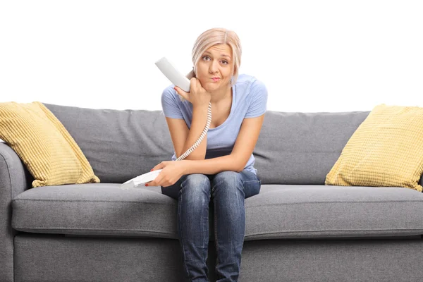 Displeased woman holding a telephone speaker — Stock Photo, Image