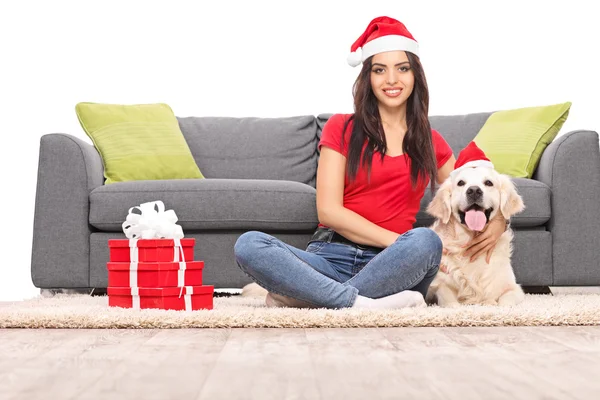 Flicka med Santa hatt sitter med hund — Stockfoto