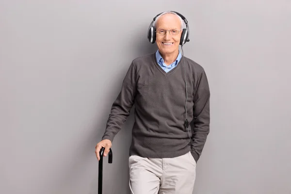 Starší muž poslech hudby na sluchátka — Stock fotografie
