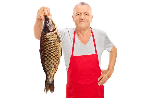 Reifer Fischhändler, der einen großen Fisch hält — Stockfoto