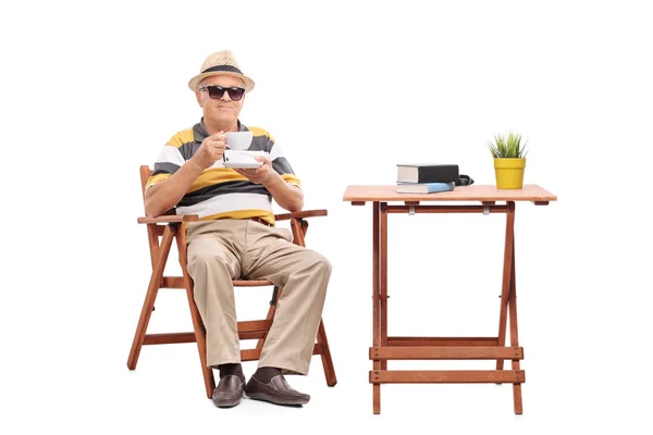 Monsieur aîné assis à une table basse — Photo