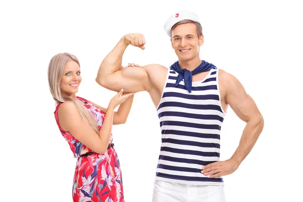 Matroos buigen zijn biceps en poseren met vriendin — Stockfoto