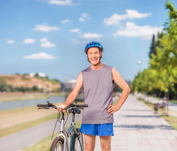 Uomo anziano in posa con la sua bicicletta — Foto Stock