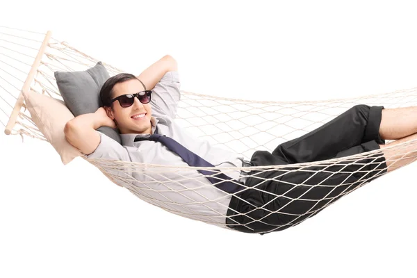 Carefree young businessman lying in a hammock — Stock Photo, Image