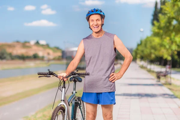 Активный пожилой человек с велосипедом — стоковое фото