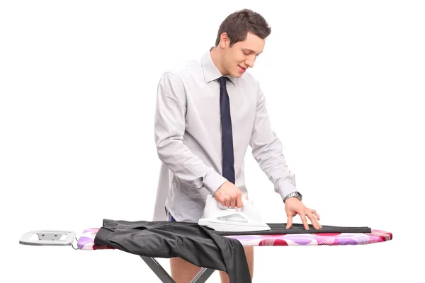 Joven planchando un par de pantalones —  Fotos de Stock