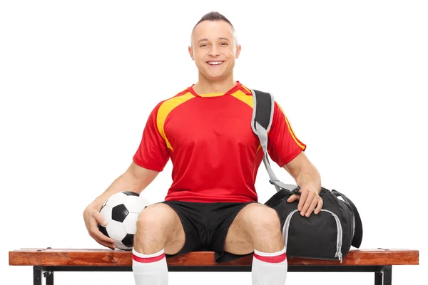 Killen i fotboll uniform innehar en fotboll — Stockfoto