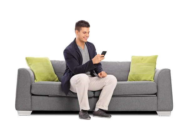 Mann auf Sofa tippt auf Handy — Stockfoto