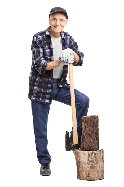 Senior man leunend op een bijl — Stockfoto