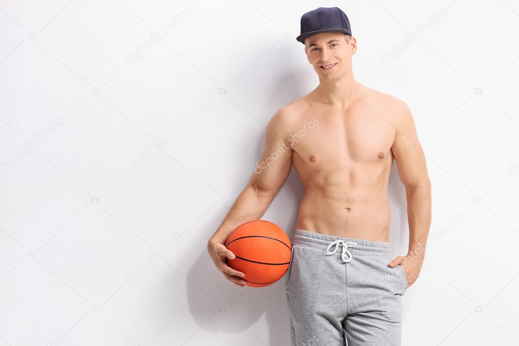 Young shirtless guy holding a basketball