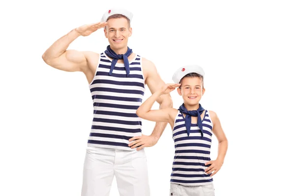 Pai e filho em uniformes de marinheiro saudando — Fotografia de Stock