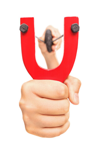 Рука держит растянутую рогатку
