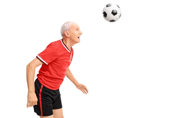 Homem sênior na direção de uma bola de futebol — Fotografia de Stock