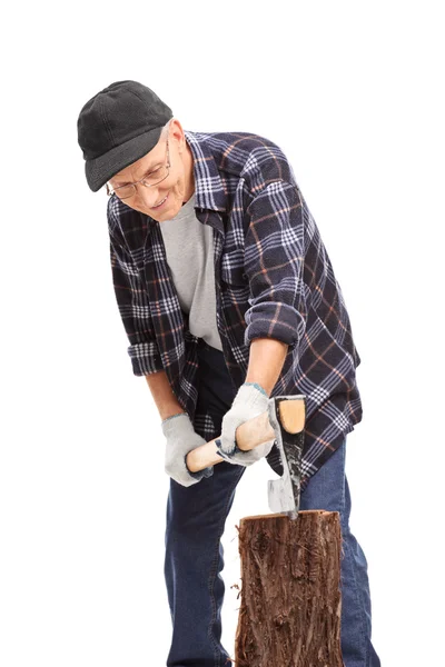 Hombre mayor dividiendo un tronco con un hacha — Foto de Stock