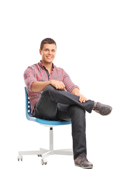 Avslappnad ung man sitter på en stol — Stockfoto