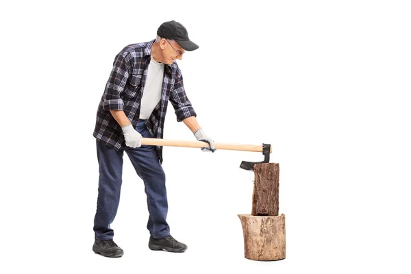 Senior splitting wood with an axe — Stock Photo, Image