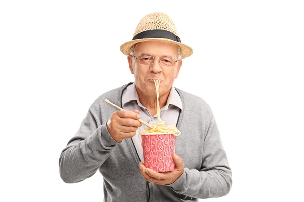 Uomo anziano mangiare tagliatelle cinesi — Foto Stock