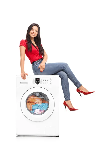 Bir çamaşır makinesi üzerinde oturan güzel kadın — Stok fotoğraf
