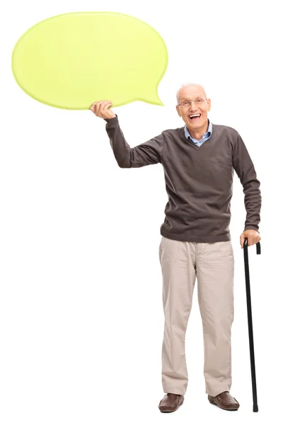 Senior gentleman holding a yellow speech bubble — Stock fotografie