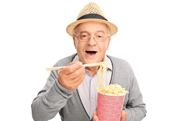 Senior gentleman eating Chinese food — Stockfoto