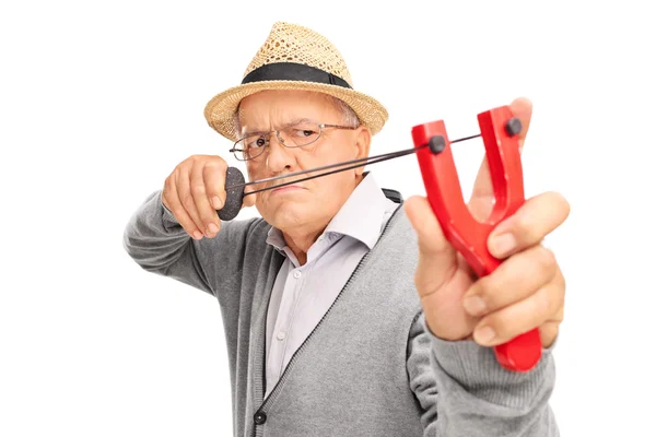 Angry senior gentleman aiming with a slingshot — Stock Photo, Image