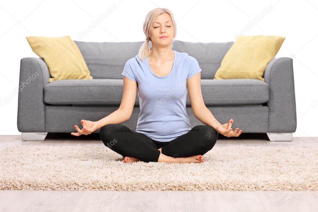 Peaceful woman meditating on the floor