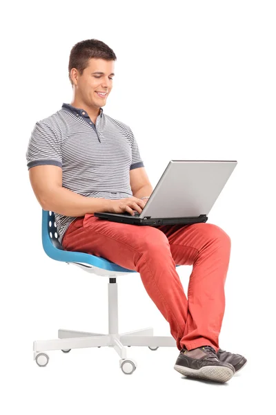 Człowiek pracuje na laptopie siedząc na krześle — Zdjęcie stockowe