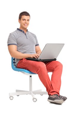 Bir sandalyeye oturmuş bir dizüstü bilgisayarda çalışan adam