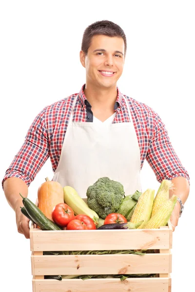 男人抱着一箱装满了蔬菜 — 图库照片