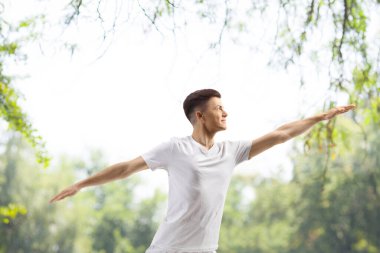 Guy practicing yoga in a park