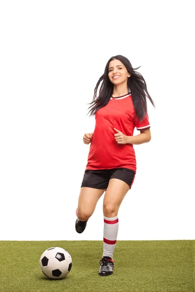 Female football player kicking a ball — Zdjęcie stockowe