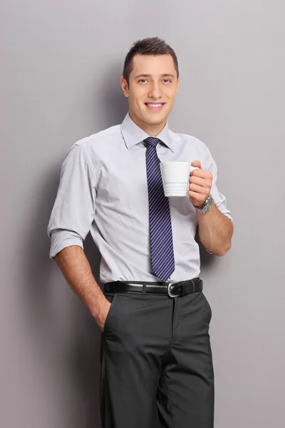 Young businessman holding a cup of coffee — Stok fotoğraf