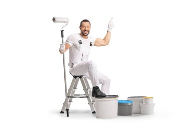 Boya kovalarıyla merdivende oturan bir ressam ve beyaz arka planda izole edilmiş bir şekilde yukarıya bakıyor.