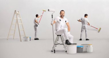 Bir grup ressam iç dekorasyon ve duvar boyama üzerinde çalışıyor.