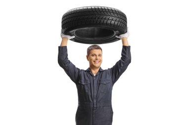 Tamirci beyaz arka planda izole edilmiş bir araba lastiğini kaldırıyor.