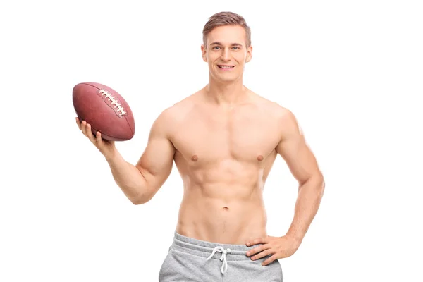 Молодой человек без рубашки держит футбольный мяч — стоковое фото