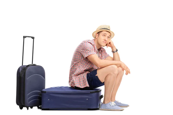 Bored tourist sitting on his baggage — Zdjęcie stockowe