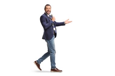 Mikrofonla konuşan ve beyaz arka planda yalnız yürüyen bir adam.