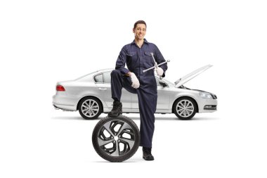 İngiliz anahtarı ve beyaz arka planda izole edilmiş araba lastiği olan bir tamirci.