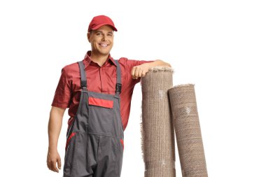 Beyaz arka planda izole edilmiş halılara yaslanan erkek işçi