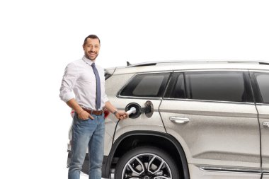 Beyaz arka planda izole edilmiş elektrikli araç istasyonunda bir SUV şarj eden adam