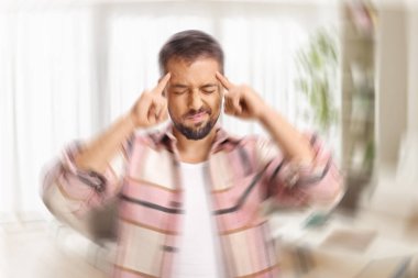 Oturma odasında sersemlemiş genç bir adam.