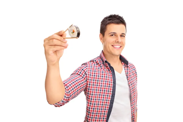 Радісний хлопець тримає шматочок суші — стокове фото