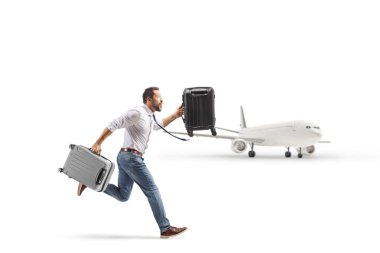 Beyaz arka planda izole edilmiş bir uçağı yakalamak için el bagajıyla koşan adam.