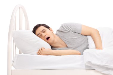 Genç adam bir yatakta uyumak