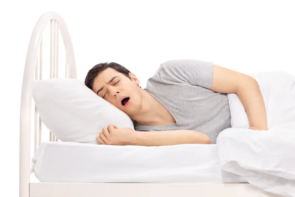 Joven durmiendo en una cama — Foto de Stock